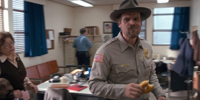 Wide shot frame from Stranger Things — standing, hat, uniform