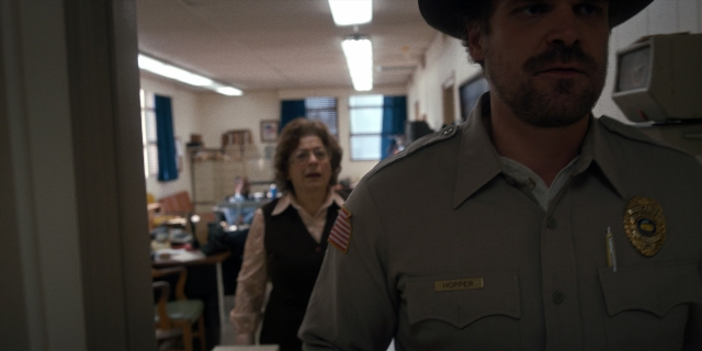 Wide shot frame from Stranger Things — standing, hat, uniform
