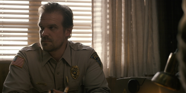 Medium shot frame from Stranger Things — sitting, room, uniform