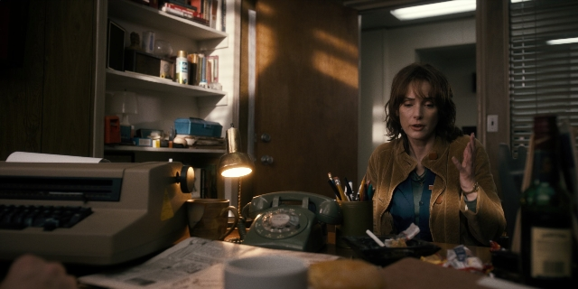 Wide shot frame from Stranger Things — sitting, desk, room