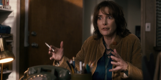 Wide shot frame from Stranger Things — sitting, room, phone
