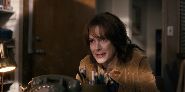 Medium shot frame from Stranger Things — sitting, room, phone