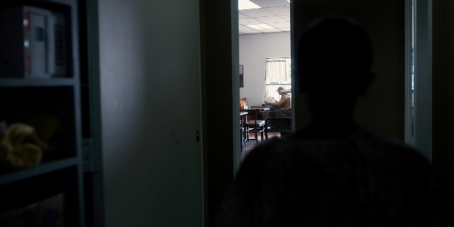 Wide shot frame from Stranger Things — sitting, standing, room