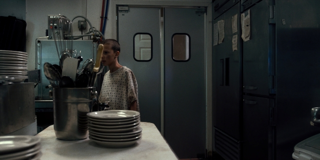 Wide shot frame from Stranger Things — standing, door, kitchen