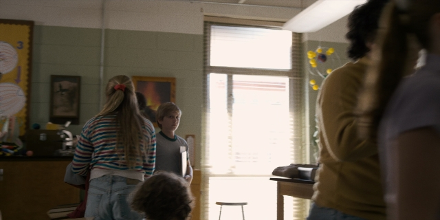 Wide shot frame from Stranger Things — standing, room, shirt