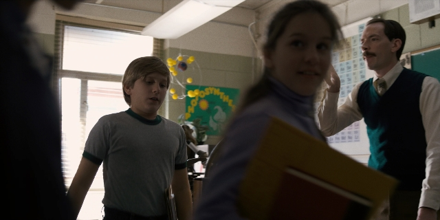 Wide shot frame from Stranger Things — standing, hand, tie