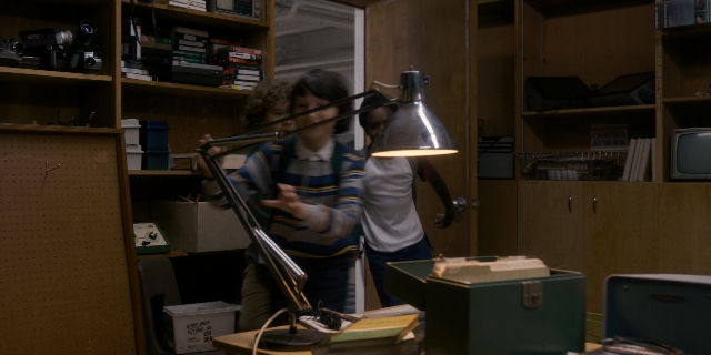 Wide shot frame from Stranger Things — book, standing, room