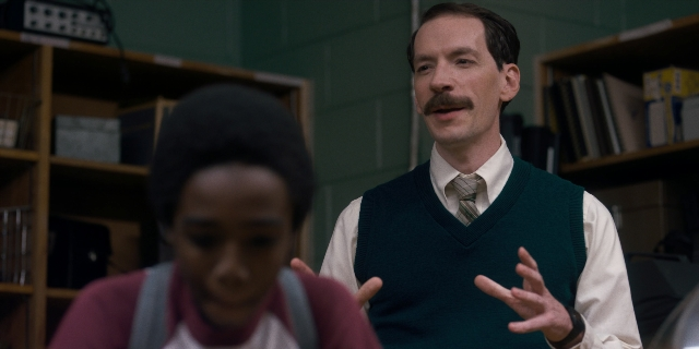 Medium shot frame from Stranger Things — standing, tie, shirt
