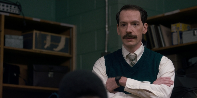 Medium shot frame from Stranger Things — standing, room, tie