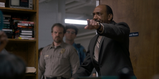 Wide shot frame from Stranger Things — room, door, uniform