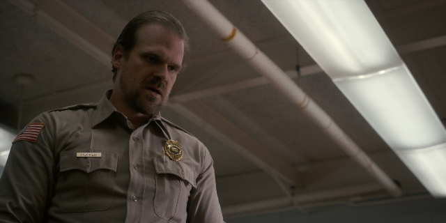 Wide shot frame from Stranger Things — standing, room, uniform
