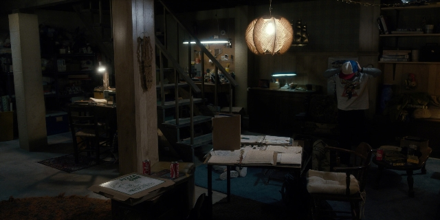 Wide shot frame from Stranger Things — standing, room, table