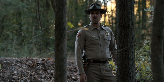 Wide shot frame from Stranger Things — standing, hat, uniform
