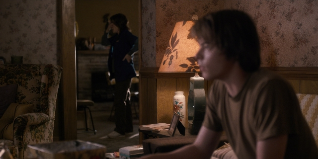 Close-up frame from Stranger Things — sitting, standing, room