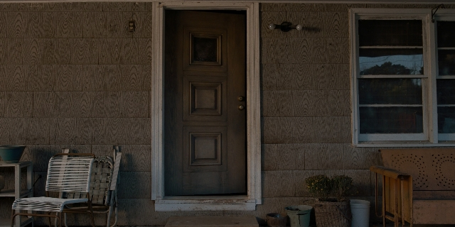 Medium shot frame from Stranger Things — table, door, house