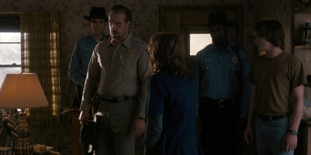 Wide shot frame from Stranger Things — sitting, standing, walking