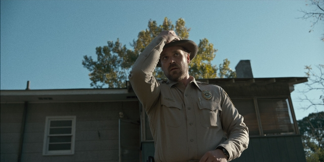 Wide shot frame from Stranger Things — standing, hat, uniform