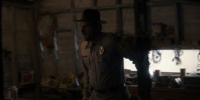 Wide shot frame from Stranger Things — standing, room, hat
