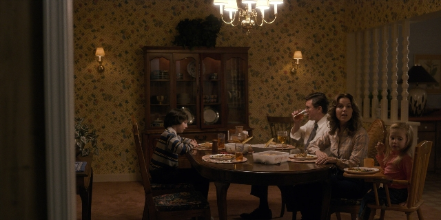 Wide shot frame from Stranger Things — sitting, room, table