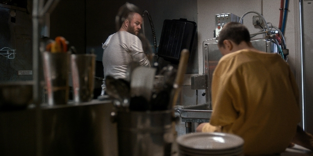 Wide shot frame from Stranger Things — sitting, plate, table
