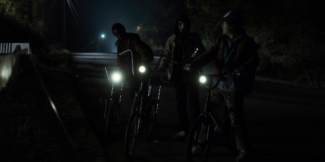 Wide shot frame from Stranger Things — standing, street, night
