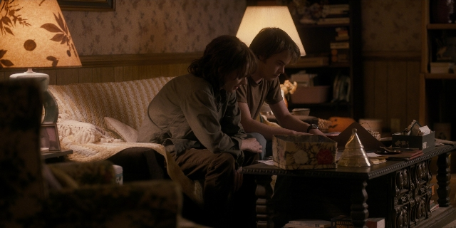 Wide shot frame from Stranger Things — sitting, room, table