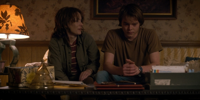 Wide shot frame from Stranger Things — sitting, book, room