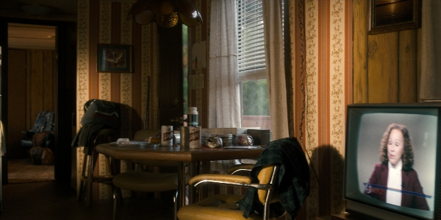 Wide shot frame from Stranger Things — room, table, door