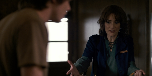 Wide shot frame from Stranger Things — sitting, standing, room