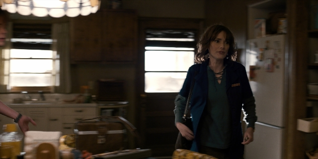 Wide shot frame from Stranger Things — standing, table, kitchen