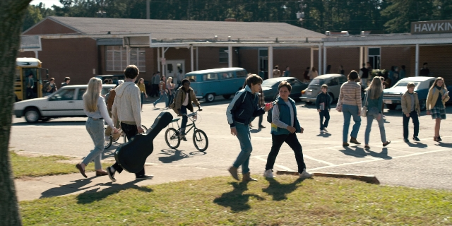 Wide shot frame from Stranger Things — standing, walking, bicycle
