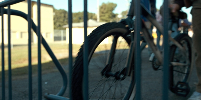 Wide shot frame from Stranger Things — bicycle, person, bicycle wheel