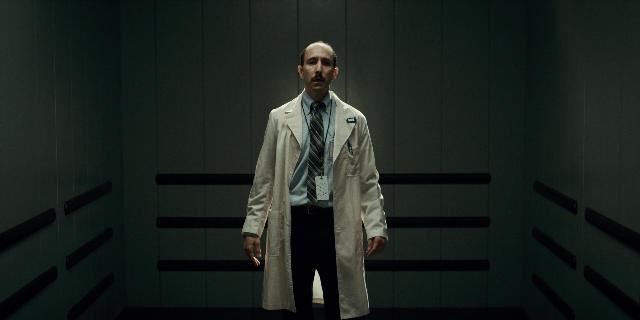 Wide shot frame from Stranger Things — standing, room, coat