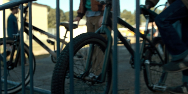 Medium shot frame from Stranger Things — hand, bicycle, wheel