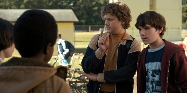 Wide shot frame from Stranger Things — standing, shirt, jacket