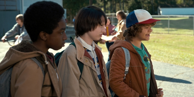 Wide shot frame from Stranger Things — sitting, standing, walking