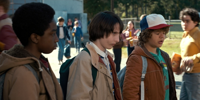 Wide shot frame from Stranger Things — standing, walking, street