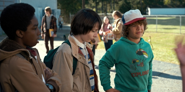Wide shot frame from Stranger Things — standing, walking, street
