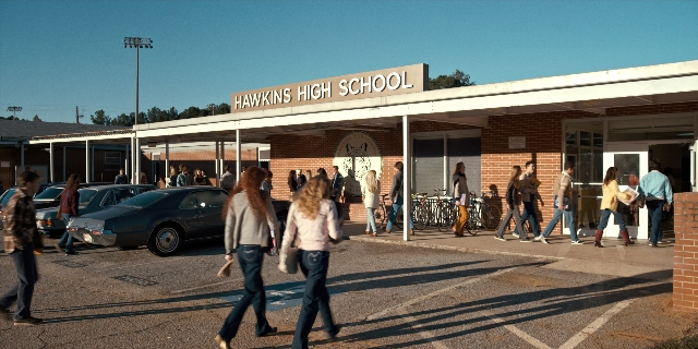 Wide shot frame from Stranger Things — walking, car, person