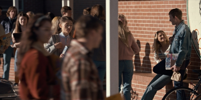 Wide shot frame from Stranger Things — standing, dialogue, door