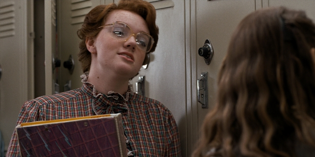 Medium shot frame from Stranger Things — book, standing, hand
