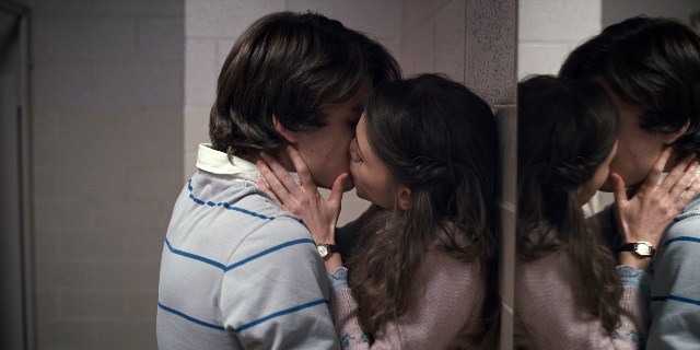 Wide shot frame from Stranger Things — standing, kiss, shirt