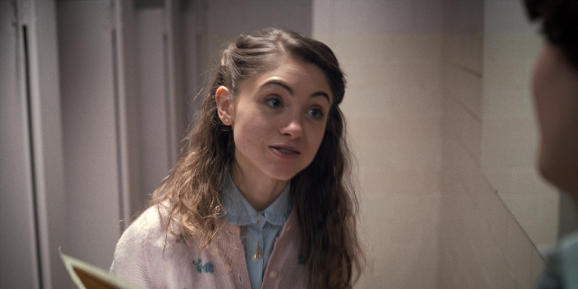 Medium shot frame from Stranger Things — standing, door, face