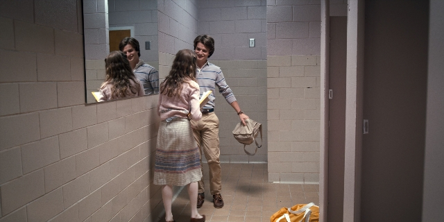 Wide shot frame from Stranger Things — book, standing, dialogue