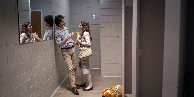 Wide shot frame from Stranger Things — book, standing, door