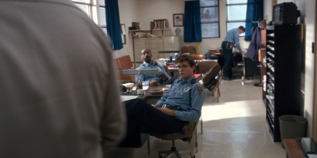 Wide shot frame from Stranger Things — sitting, room, table