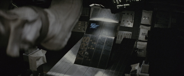 Wide shot frame from Interstellar — room, hand, person