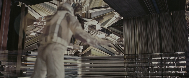 Wide shot frame from Interstellar — standing, room, suit