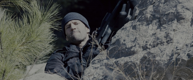 Wide shot frame from Fast & Furious 7 — hand, gun, beard