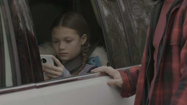 Wide shot frame from Daddy's Home 2 — sitting, phone, street